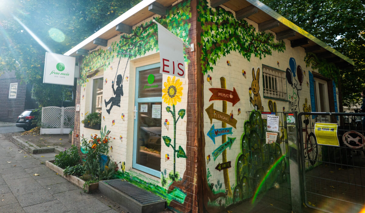 Blick auf Frau Meis Eis · Café von der Straße aus, das Haus ist mit farbenfrohen Graffiti und Zeichnungen geschmückt